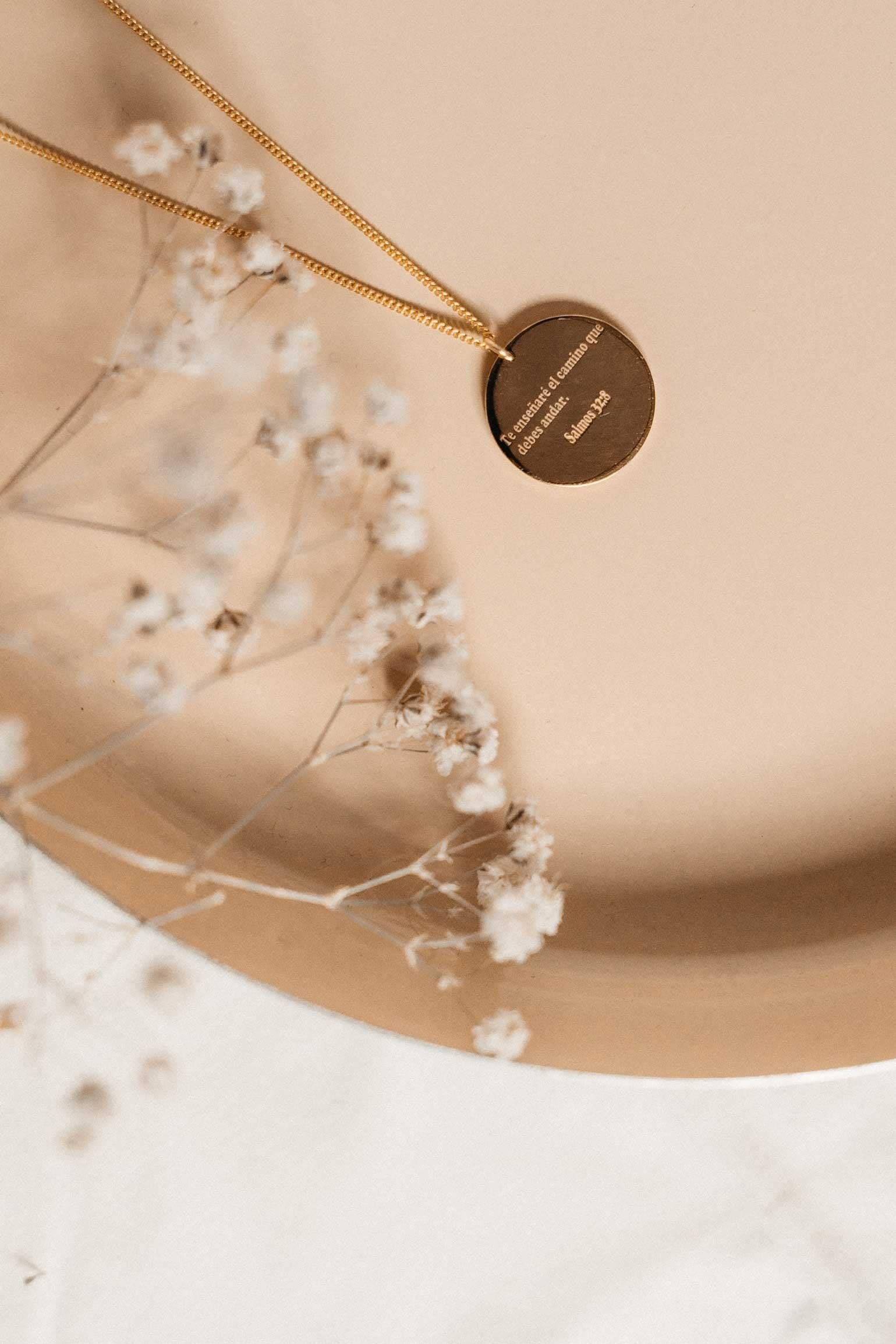 Elegant gold necklace with engraved pendant, minimalist jewellery design for special occasions.